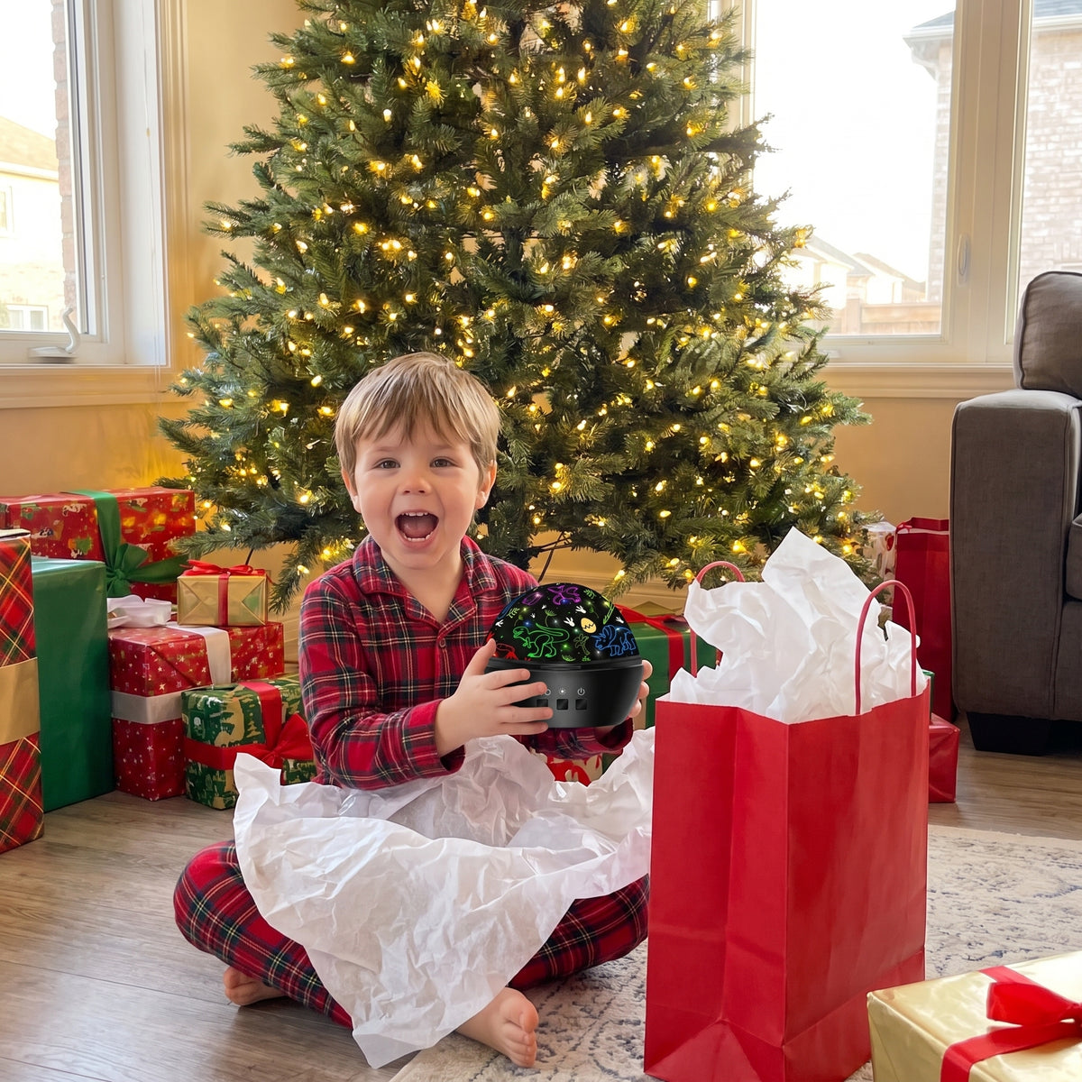 Boy unwrapping the dino projector on Christmas morning